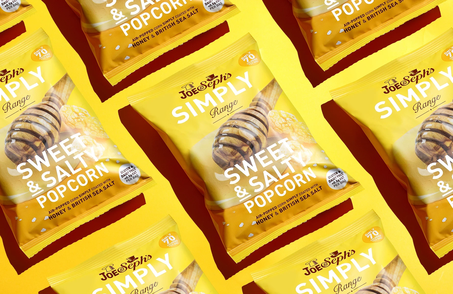 Commercial product photography at London studio of Joe & Seph’s Simply Range sweet and salty popcorn bags on a yellow background.