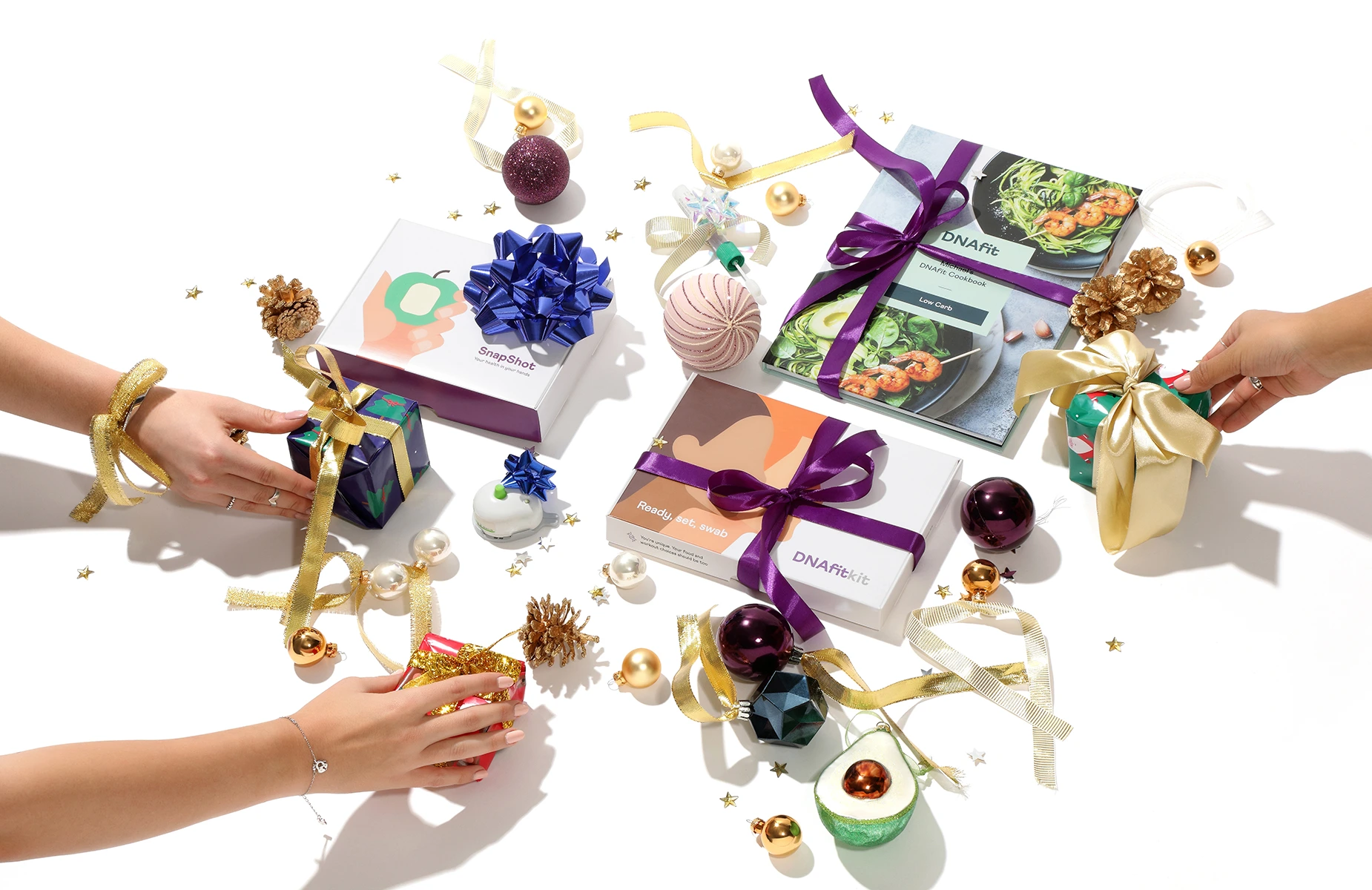 Christmas advertising photography of DNAfit health kits and cookbook styled with wrapped gifts, ribbons and festive decorations.
