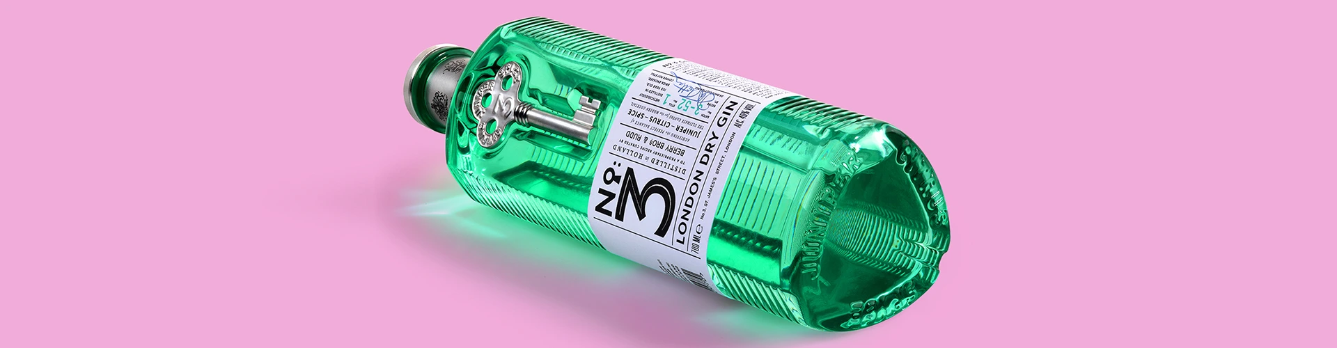 Advertising product photography of a No. 3 London Dry Gin bottle against a pink background.